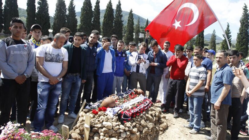 People mourn at graves for miners who died in Tuesday's mine disaster, at a cemetery in Soma, a district in Turkey's western province of Manisa May 18, 2014. Turkish police have detained 18 people, including mining company executives and personnel, as part of an investigation into last week's mine disaster, CNN Turk and other broadcasters reported on Sunday. The rescue operation ended on Saturday after the bodies of the last two workers were carried out, bringing the death toll in Turkey's worst industrial 