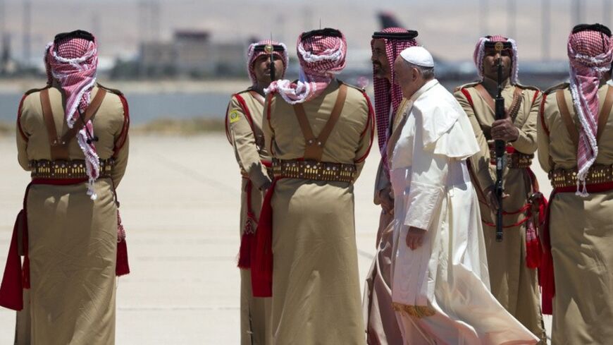 Pope Francis (3rd R) reviews the honour guard upon his arrival at Queen Alia International airport in Amman May 24, 2014. Pope Francis arrives in Jordan on Saturday to start an intense three-day trip to the Middle East, bringing hope to the dwindling Christian population and an appeal to members of all religions to work together for peace.  REUTERS/Andrew Medichini/Pool (JORDAN - Tags: RELIGION) - RTR3QN4C