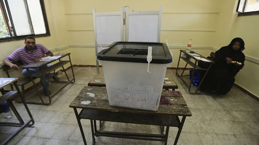 Election officials wait for voters inside a polling station on the second day of voting in the Egyptian election in Cairo, May 27, 2014. Former army chief Abdel Fattah al-Sisi is expected to emerge from a second and final day of voting on Tuesday as Egypt's next head of state, returning the presidency to a military man as hopes for democracy fade three years after Hosni Mubarak's downfall. REUTERS/Amr Abdallah Dalsh (EGYPT - Tags: POLITICS ELECTIONS) - RTR3R0Y7