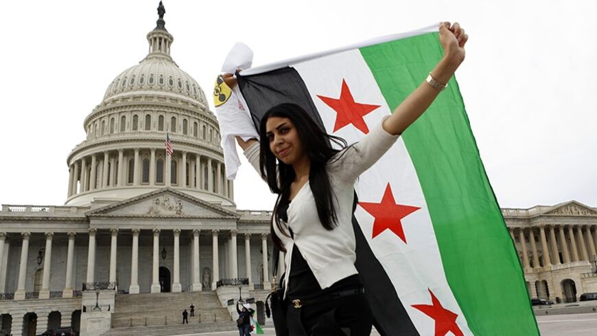 An anti-Assad protester carries the Syrian freedom flag in front of the U.S. Capitol in Washington September 9,  2013.  White House efforts to convince the U.S. Congress to back military action against Syria are not only failing, they seem to be stiffening the opposition. That was the assessment on Sunday, not of an opponent but of an early and ardent Republican supporter of Obama's plan for attacking Syria, the influential Republican chairman of the House intelligence committee, Mike Rogers. Congress will 