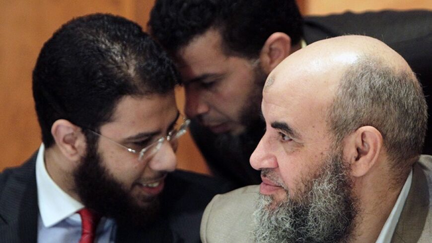 Nour party spokesman Nader Bakkar (L), chats with a party member next to Younes Makhyoun (R), the head of the party, during a news conference about constitution in Cairo December 5, 2013. The Islamist party that backed the army's ouster of President Mohamed Mursi urged Egyptians to vote in favor of a new constitution in an upcoming referendum, saying that would spare the country more turmoil. REUTERS/Mohamed Abd El Ghany  (EGYPT - Tags: POLITICS RELIGION) - RTX164ZM