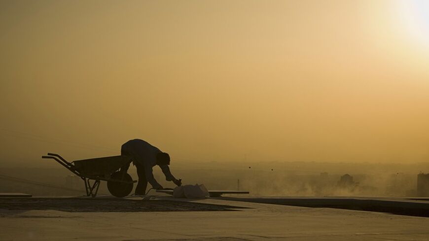 EDITORS' NOTE:  Reuters and other foreign media are subject to Iranian restrictions on their ability to film or take pictures in Tehran.

The sun sets as a labourer works on the grounds of Tehran's Milad Tower October 19, 2010. Picture taken October 19. REUTERS/Caren Firouz  (IRAN - Tags: CITYSCAPE EMPLOYMENT BUSINESS) - RTXTMW5