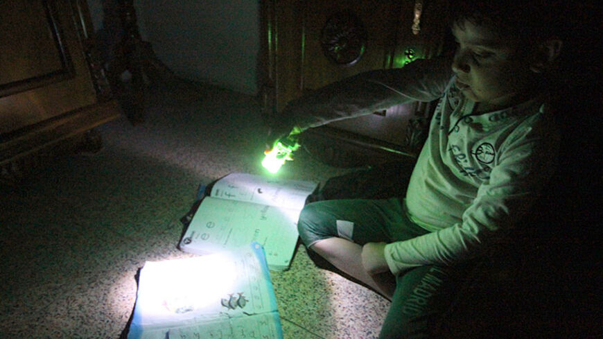 TO GO WITH AFP STORY BY SALAM FARAJ
An Iraqi boy uses the light at the end of a lighter to study during a power outage in Baghdad on March 19, 2014. As recently as the 1970s, the Iraqi capital was lauded as a model city in the Arab world, but now, after decades of seemingly endless conflict, it is the world's worst city according to the latest survey by the Mercer consulting group. AFP PHOTO/ALI AL-SAADI        (Photo credit should read ALI AL-SAADI/AFP/Getty Images)