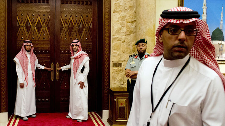 Aides stand outside the room where US President Barack Obama meets with Saudi King Abdullah, at Rawdat Khurayim, the Saudi King Abdullah's desert camp 60 KM (35 miles) northeast of Riyadh, during his meeting with US President Barack Obama on March 28, 2014. Obama arrived in Riyadh for talks with Saudi King Abdullah as mistrust fuelled by differences over Iran and Syria overshadows a decades-long alliance between their countries. AFP PHOTO / SAUL LOEB (Photo credit should read SAUL LOEB/AFP/Getty Imag