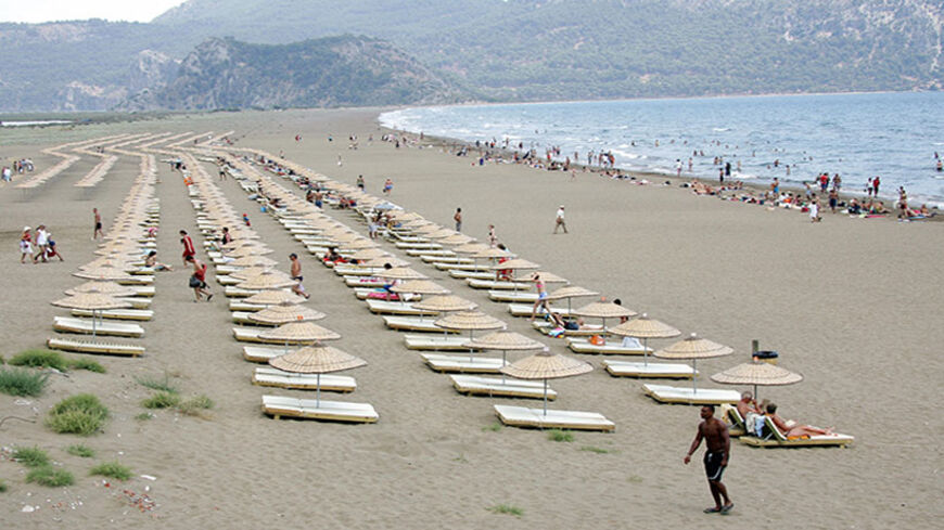 Mugla, TURKEY:  People sunbathe at Iztuzu beach 13km from Dalyan, 27 June 2006. Iztuzu beach is one of the rare beaches in the world where Caretta Caretta (loggerhead turtles) leave their eggs, and human activities on this beach are limited. AFP PHOTO/MUSTAFA OZER  (Photo credit should read MUSTAFA OZER/AFP/Getty Images)