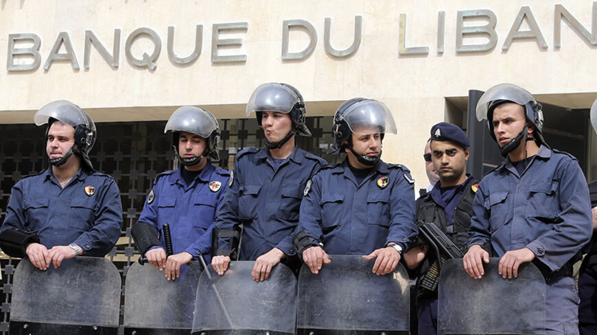 Lebanese riot police stand guard at the Lebanese Central Bank in Beirut February 25, 2013. An open-ended strike by teachers and civil servants entered its second week today for the government to approve the wage hike proposal. REUTERS/Mohamed Azakir (LEBANON - Tags: POLITICS CIVIL UNREST) - RTR3E9U4
