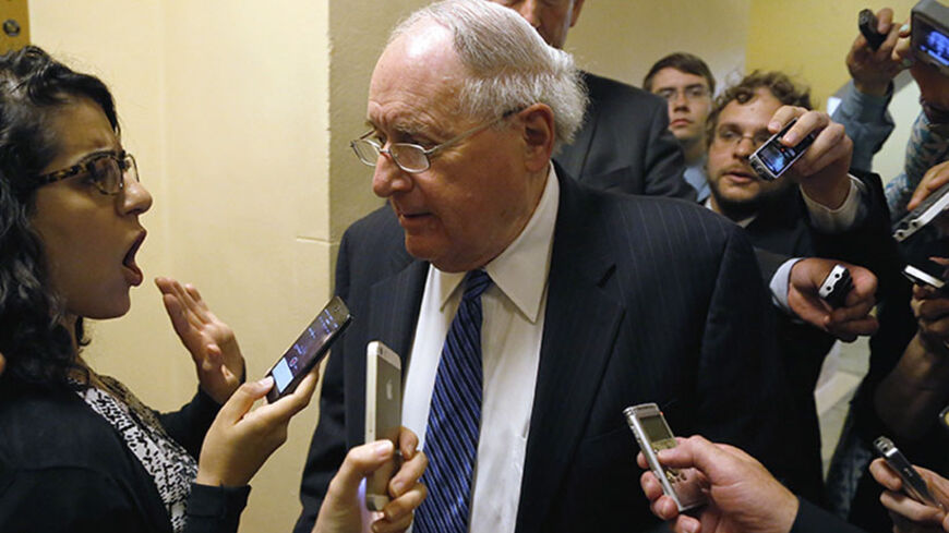 Senator Carl Levin (D-MI) (C) is trailed by reporters outside of a closed-door Senate Armed Services Committee briefing on the Bergdahl prisoner swap at the U.S. Capitol in Washington June 10, 2014. The White House has been trying to appease angry lawmakers since U.S. President Barack Obama announced on May 31 that U.S. Army Sergeant Bowe Bergdahl had been exchanged for the five inmates from the U.S. military prison at Guantanamo Bay in Cuba. REUTERS/Jonathan Ernst  (UNITED STATES - Tags: POLITICS MILITARY)