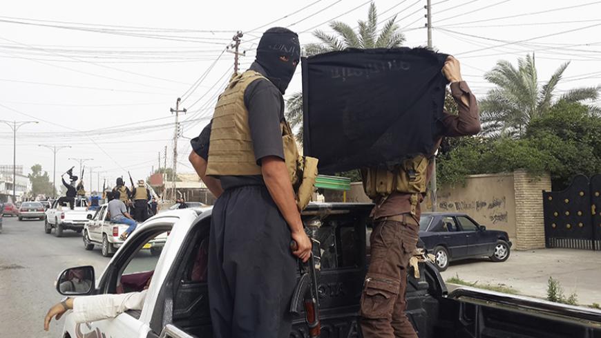 Fighters of the Islamic State of Iraq and the Levant (ISIL) celebrate on vehicles taken from Iraqi security forces, at a street in city of Mosul, June 12, 2014. Since Tuesday, black clad ISIL fighters have seized Iraq's second biggest city Mosul and Tikrit, home town of former dictator Saddam Hussein, as well as other towns and cities north of Baghdad. They continued their lightning advance on Thursday, moving into towns just an hour's drive from the capital. Picture taken June 12, 2014. REUTERS/Stringer (I