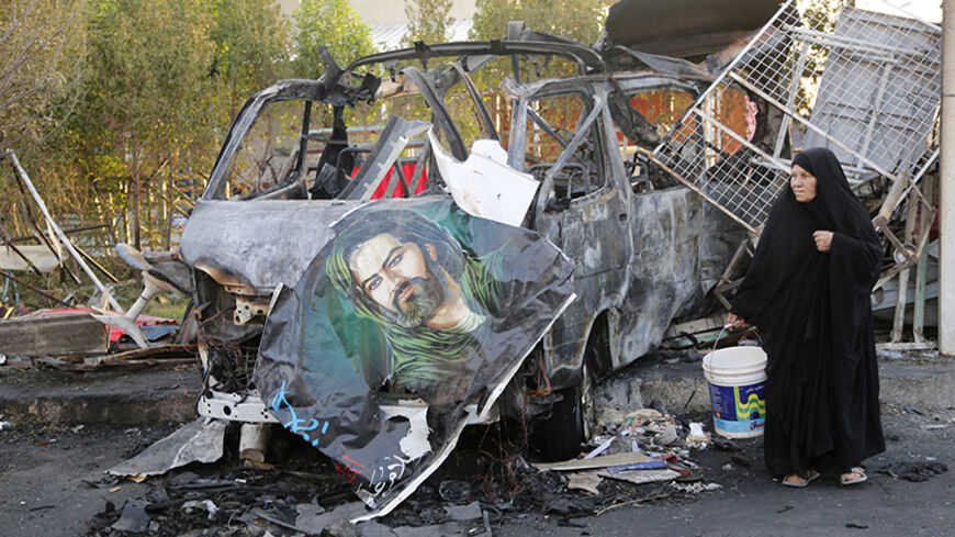 A woman walks past the site of a car bomb attack in Baghdad's Sadr City, June 18, 2014. At least 13 people were killed and 30 others wounded in a car bomb explosion in Baghdad's mainly Shi'ite neighbourhood of Sadr City, according to police and hospital officials.  REUTERS/Wissm al-Okili (IRAQ - Tags: CIVIL UNREST POLITICS) - RTR3UDVU