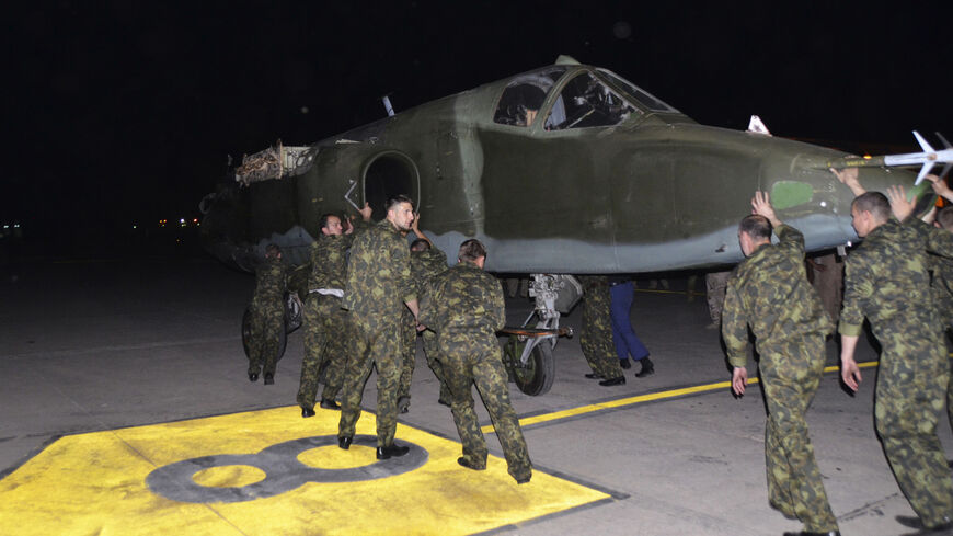 Russian soldiers unload a Russian Sukhoi SU-25 plane in al-Muthanna Iraqi military base at Baghdad airport in Baghdad, June 28, 2014. The first batch of Russian fighter jets arrived in Baghdad on Saturday to help Iraqi forces battle Islamic State of Iraq and the Levant (ISIL) fighters in the country's north. Picture taken June 28, 2014.  REUTERS/Stringer (IRAQ - Tags: POLITICS MILITARY TRANSPORT CIVIL UNREST CONFLICT) - RTR3W9NZ