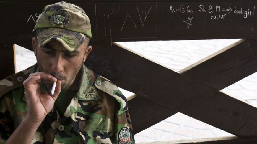 A member of the Iranian army smokes as he rests at a park in central Tehran, April 9, 2009. Reform minded youth see America as the land of opportunity and would like to see ties with the U.S. restored but conservative minded youth see the U.S. as the enemy and feel that the Islamic Revolution's goals must be kept alive.   REUTERS/Raheb Homavandi         (IRAN) - RTXDXV8