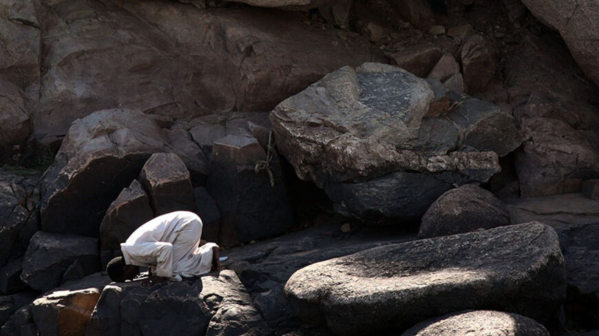 Nubian man prays on rocks below the Philae temple complex near the southern Egyptian city of Aswan November 7, 2009. The earliest remains of the temple date from the reign of Nectanebo I in the third century BC and are now one of Egypt's legendary tourist attractions. REUTERS/Goran Tomasevic  (EGYPT SOCIETY) - RTXQGP4