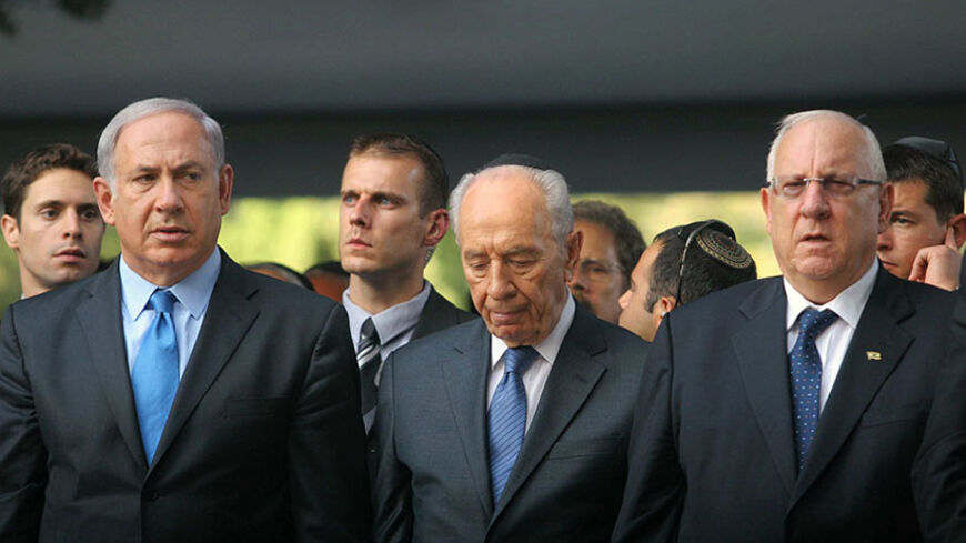 Israel's Prime Minister Benjamin Netanyahu (L) stands with President Shimon Peres and Speaker of the parliament Reuven Rivlin (R) during a memorial ceremony on Mount Herzl military cemetery in Jerusalem marking the anniversary of the assassination of Prime Minister Yitzhak Rabin October 20, 2010. Israel marks on Wednesday the 15th anniversary of Rabin's assassination by an ultra-nationalist Jew. REUTERS/Alex Kolomoisky/Pool (JERUSALEM - Tags: POLITICS ANNIVERSARY) - RTXTN9O