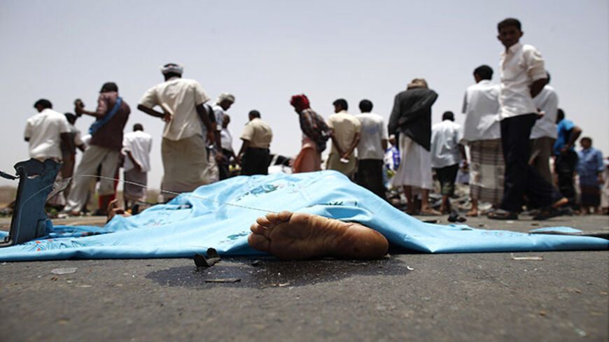 ATTENTION EDITORS - VISUAL COVERAGE OF SCENES OF INJURY OR DEATH
A covered body is seen as policemen and people check the scene of a collision on a highway leading to a border crossing between Yemen and Saudi Arabia May 18, 2013. At least 13 people were killed as two cars ran into each other and caught fire after the collision, burning some occupants to death, police officials at the scene said. Yemen is among the countries with the world's highest rates of traffic fatalities. Traffic accidents claimed th