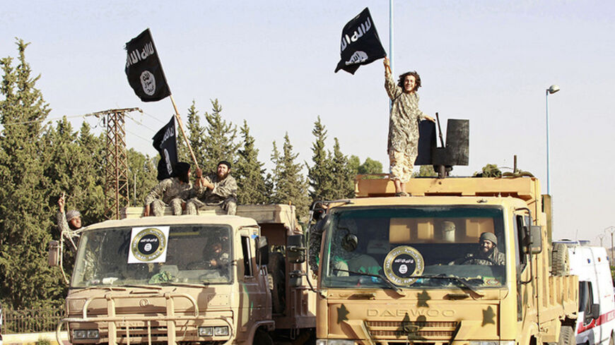 Militant Islamist fighters wave flags as they take part in a military parade along the streets of Syria's northern Raqqa province June 30, 2014. Militant Islamist fighters held a parade in Syria's northern Raqqa province to celebrate their declaration of an Islamic "caliphate" after the group captured territory in neighbouring Iraq, a monitoring service said. The Islamic State, an al Qaeda offshoot previously known as Islamic State in Iraq and the Levant (ISIL), posted pictures online on Sunday of people wa