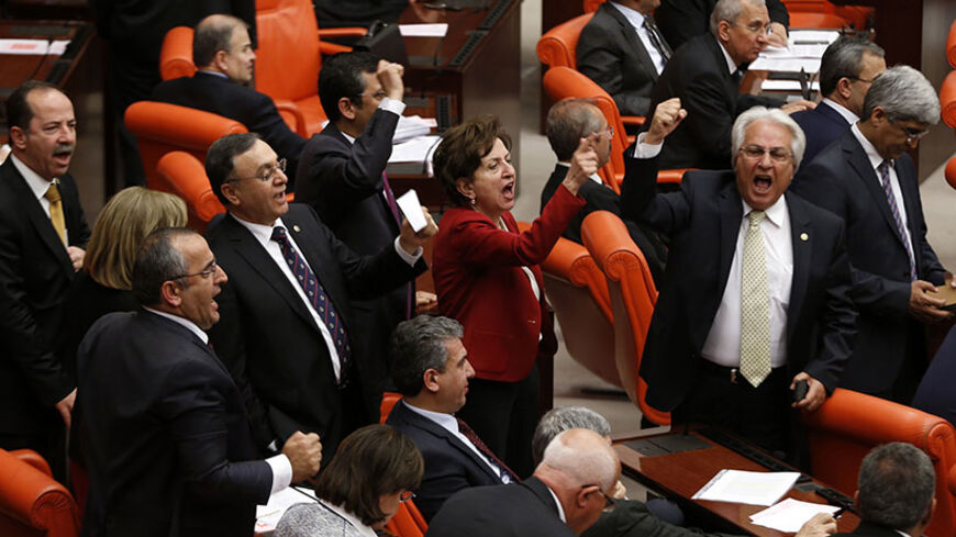 MPs of Turkey's main opposition Republican People's Party (CHP) shout slogans against the ruling AK Party (AKP) during a debate in Ankara March 19, 2014. Parliament convened in the capital Ankara for the hearing of a prosecutor report allegedly outlining the role of four former ministers in a corruption scandal that became public in December 2013. REUTERS/Umit Bektas (TURKEY - Tags: POLITICS) - RTR3HS83