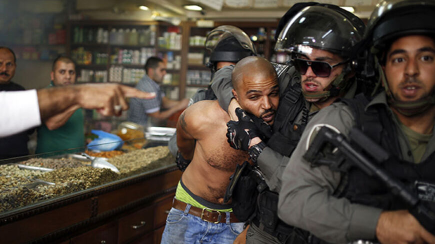 An Israeli border policeman detains a Palestinian protestor during clashes ahead of Land Day in east Jerusalem March 29, 2014. Land Day which is observed on Sunday in Israel commemorates the killing by security forces of six Arabs in 1976 during protests against government plans to confiscate land in northern Israel's Galilee region. REUTERS\Amir Cohen (JERUSALEM - Tags: POLITICS CIVIL UNREST TPX IMAGES OF THE DAY) - RTR3J44S