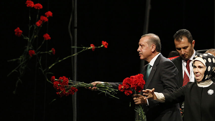 Turkish Prime Minister Tayyip Erdogan throws flowers to his supporters next to his wife Emine during his visit in Cologne May 24, 2014. REUTERS/Wolfgang Rattay (GERMANY - Tags: POLITICS TPX IMAGES OF THE DAY) - RTR3QOHJ