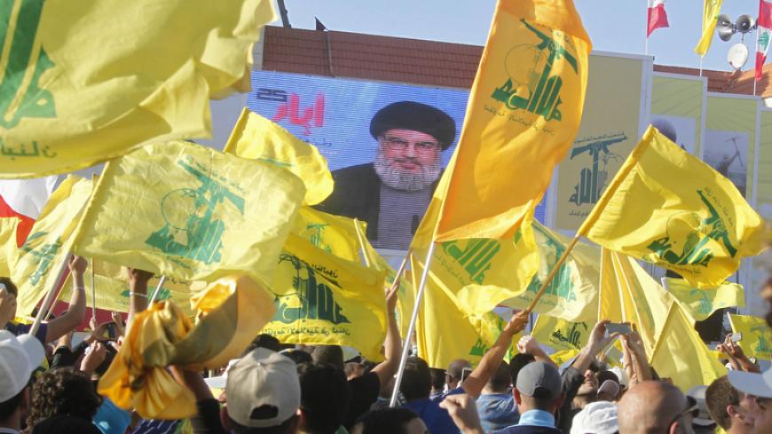 Residents watch Hezbollah leader Sayyed Hassan Nasrallah on a screen during his televised speech at a festival celebrating Resistance and Liberation Day, in Bint Jbeil May 25, 2014. The event commemorates the 14th anniversary of Israel's withdrawal from southern Lebanon. REUTERS/Sharif Karim (LEBANON - Tags: POLITICS ANNIVERSARY) - RTR3QT8E