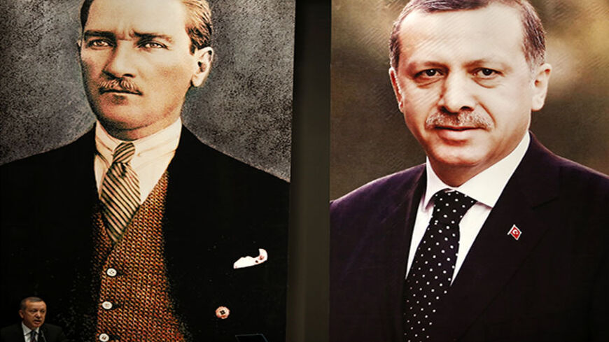 Turkey's Prime Minister Tayyip Erdogan addresses the audience at a meeting at his ruling Ak Party (AKP) headquarters in Ankara June 25, 2014, as he stands in front of the huge portraits of Mustafa Kemal Ataturk, founder of modern Turkey, and himself.  REUTERS/Umit Bektas (TURKEY - Tags: POLITICS) - RTR3VNAV