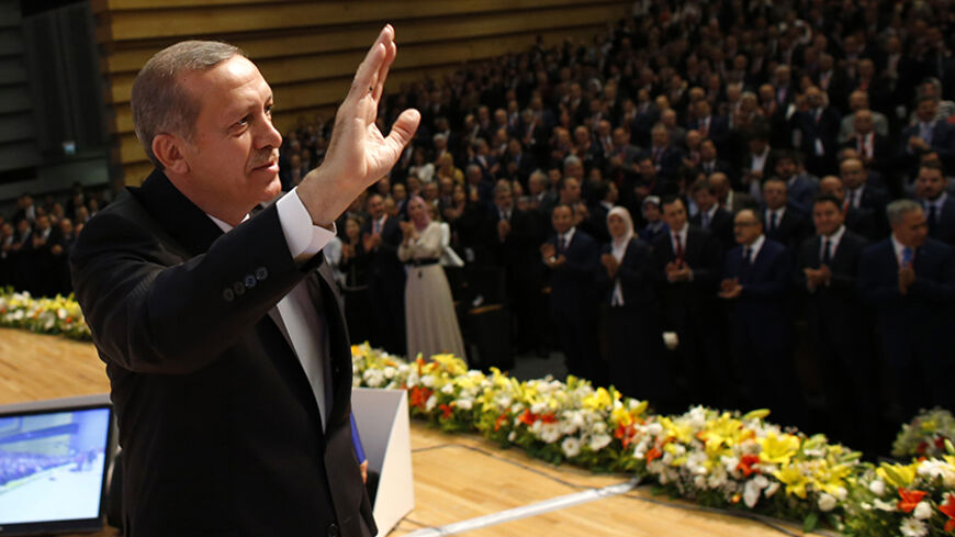 Turkey's Prime Minister Tayyip Erdogan greets AK Party (AKP) members at a meeting where he is named as his party's candidate for the country's first direct presidential election in Ankara July 1, 2014. Tayyip Erdogan declared his candidacy on Tuesday for a more powerful presidency which rivals fear may entrench authoritarian rule and supporters, especially conservative Muslims, see as the crowning prize in his drive to reshape NATO member Turkey. REUTERS/Umit Bektas (TURKEY - Tags: POLITICS) - RTR3WM8F