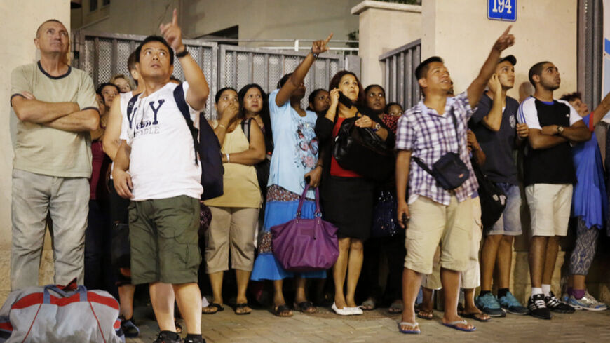 People point to an iron dome missile trail, after an iron dome was fired to intercept an incoming rocket, during an air raid siren warning of a rocket attack in Tel Aviv July 12, 2014. Hamas militants launched ten rockets at Tel Aviv on Saturday, causing no casualties or damage, in the largest salvo yet on Israel's main business hub, since Israel launched its Gaza offensive against the Islamist group, five days ago. REUTERS/Finbarr O'Reilly (ISRAEL - Tags: POLITICS MILITARY CIVIL UNREST CONFLICT) - RTR3YB2W