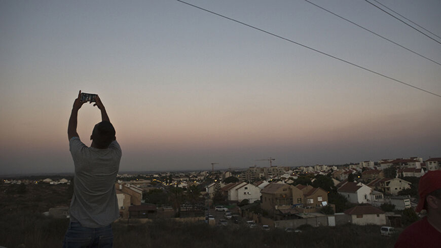 An Israeli teen takes a selfie, with the Gaza Strip on his background, on a hill near Sderot, opposite the northern Gaza Strip July 13, 2014. Thousands fled their homes in a Gaza town on Sunday after Israel warned them to leave ahead of threatened attacks on rocket-launching sites, on the sixth day of an offensive that Palestinian officials said has killed at least 160 people. Militants in the Hamas-ruled Gaza Strip kept up rockets salvoes deep into the Jewish state and the worst bout of Israel-Palestinian