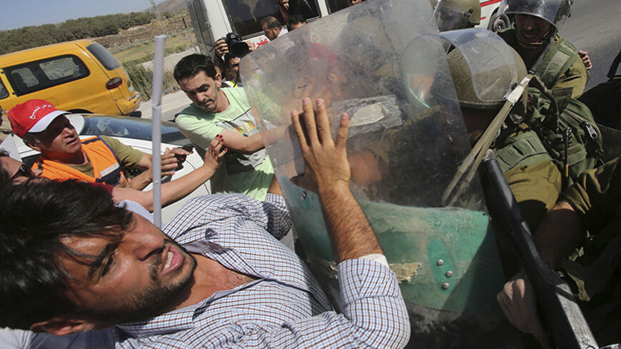 Israeli soldiers scuffle with Palestinian protesters during a protest against the Israeli air strikes in Gaza strip, at Hawara checkpoint near the West Bank city of Nablus, July 14, 2014. Palestinian militants resumed rocket attacks on Tel Aviv on Monday after a 24-hour lull in strikes on the Israeli commercial capital, and Israel kept up its air and naval bombardments of the Gaza Strip despite growing international pressure for a ceasefire. Around half a dozen Israelis have been wounded since the start of