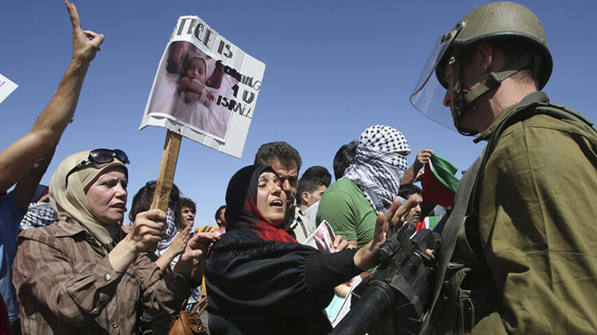 Palestinian protesters argue with Israeli soldiers during a protest against the Israeli air strikes in Gaza strip, at Hawara checkpoint near the West Bank city of Nablus, July 14, 2014. Palestinian militants resumed rocket attacks on Tel Aviv on Monday after a 24-hour lull in strikes on the Israeli commercial capital, and Israel kept up its air and naval bombardments of the Gaza Strip despite growing international pressure for a ceasefire. Around half a dozen Israelis have been wounded since the start of th