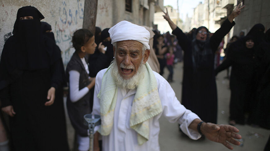Relatives of Palestinian man Hussien Abu al-Naja, whom medics said was killed in an Israeli air strike, mourn during his funeral on the Muslim holiday of Eid al-Fitr in Khan Younis in the southern Gaza Strip July 28, 2014. One of the most joyous days in the Muslim calendar, the holiday of Eid al-Fitr was marked on Monday by tears and sorrow in the Gaza Strip, left battered by three weeks of merciless fighting between Israel and Hamas Islamists. REUTERS/Ibraheem Abu Mustafa (GAZA - Tags: POLITICS CIVIL UNRES