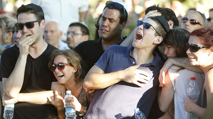 Friends of Israeli soldier Matan Gotlib mourn during his funeral in Rishon Lezion, near Tel Aviv July 31, 2014. Gotlib was killed on Wednesday by a booby trap detonated as he and 2 other soldiers uncovered a tunnel shaft, the army said. Prime Minister Benjamin Netanyahu, facing international alarm over a rising civilian death toll in Gaza, said on Thursday he would not accept any ceasefire that stopped Israel completing the destruction of militants' infiltration tunnels. Gaza officials say at least 1,394 Pa