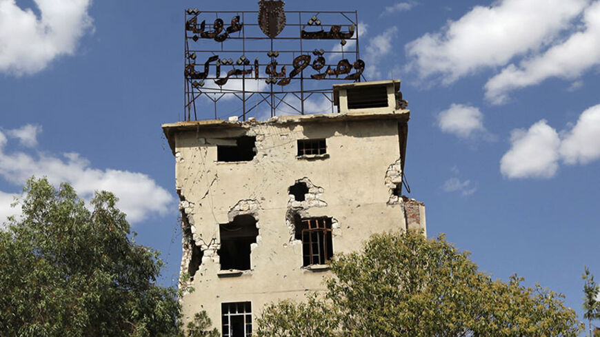 The words: ' Baath, Arabism, Unity, Freedom, Socialism' are seen on top of a damaged building that belongs to forces loyal to Syria's President Bashar al-Assad in Aleppo, June 19, 2013. Picture taken June 19, 2013. REUTERS/Nour Kelze  (SYRIA - Tags: CIVIL UNREST POLITICS CONFLICT) - RTX10UMG
