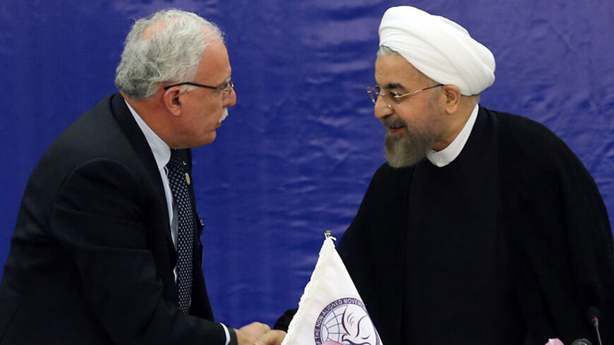 Palestinian Foreign Minister Riyad al-Maliki (L) and Iranian President Hassan Rouhani shake hands during a meeting in Tehran held by the Palestine Committee of the Non-Aligned Movement (NAM) on August 4, 2014 on the situation in Gaza. Rouhani denounced the inaction of the Security Council of the United Nations response to the "slaughter" of Palestinians by Israel. AFP PHOTO/ATTA KENARE (Photo credit should read ATTA KENARE/AFP/Getty Images)