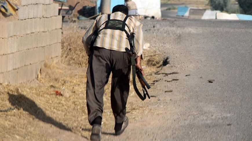 A Iraqi Turkmen Shiite fighter, who volunteered to join the government forces, runs for cover on August 4, 2014 in Amerli, some 160 kilometres (100 miles) north of Baghdad, as the city has been completely surrounded by Islamic State (IS) Sunni militants for more than six weeks. Residents say a humanitarian disaster is imminent in the town, which has been without power and drinking water for days. IS fighters, who run large swathes of neighbouring Syria, launched a blistering offensive on June 9 that saw the