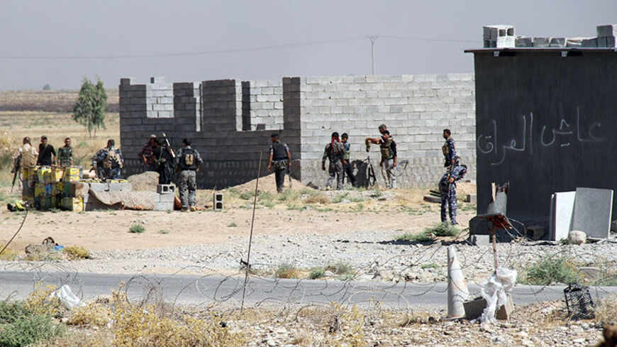 Iraqi security forces and Turkmen Shiite fighters, who volunteered to join the government forces, hold a position on August 4, 2014 in Amerli, some 160 kilometres (100 miles) north of Baghdad, as the city has been completely surrounded by Islamic State (IS) Sunni militants for more than six weeks. Residents say a humanitarian disaster is imminent in the town, which has been without power and drinking water for days. IS fighters, who run large swathes of neighbouring Syria, launched a blistering offensive on
