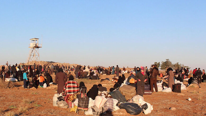 Displaced Syrian families gather next to a Turkish watchtower as they hope to cross the border into Turkey near the northern Syrian village of Shamarin, in the rebel-held province of Aleppo, on February 5, 2014. Children enduring the war in Syria have suffered terrible abuses, with the government and allied militia responsible for many killings, maiming and torture, according to a grim UN report. AFP PHOTO / BARAA AL-HALABI        (Photo credit should read BARAA AL-HALABI/AFP/Getty Images)