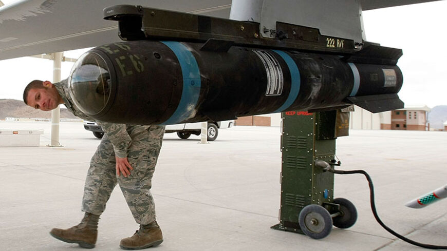 INDIAN SPRINGS, NV - APRIL 16: Airman 1st Class Ozzy Toma walks around an inert Hellfire missile as he perform a pre-flight check on an MQ-1B Predator unmanned aircraft system (UAS) April 16, 2009 at Creech Air Force Base in Indian Springs, Nevada. The United States Air Force currently has 116 of the aircraft in its UAS fleet with 31 of them airborne at any given moment, flying combat air patrols over Iraq and Afghanistan. After being launched overseas, the Predators are flown by pilots and sensor operator