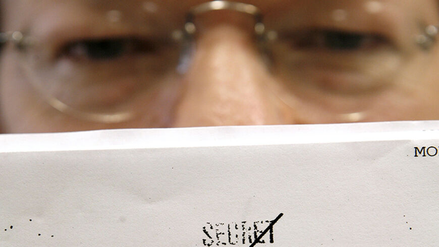 National Security Archive Deputy Director Malcolm Byrne holds one of the "Family Jewels" documents released by the CIA at the National Security Archive at George Washington University in Washington June 26, 2007.  The CIA aired its dirty laundry by declassifying hundreds of pages of long-secret records that detail some of the agency's worst illegal abuses during about 25 years of overseas assassination attempts, domestic spying and kidnapping.      REUTERS/Kevin Lamarque (UNITED STATES) - RTR1R6GH