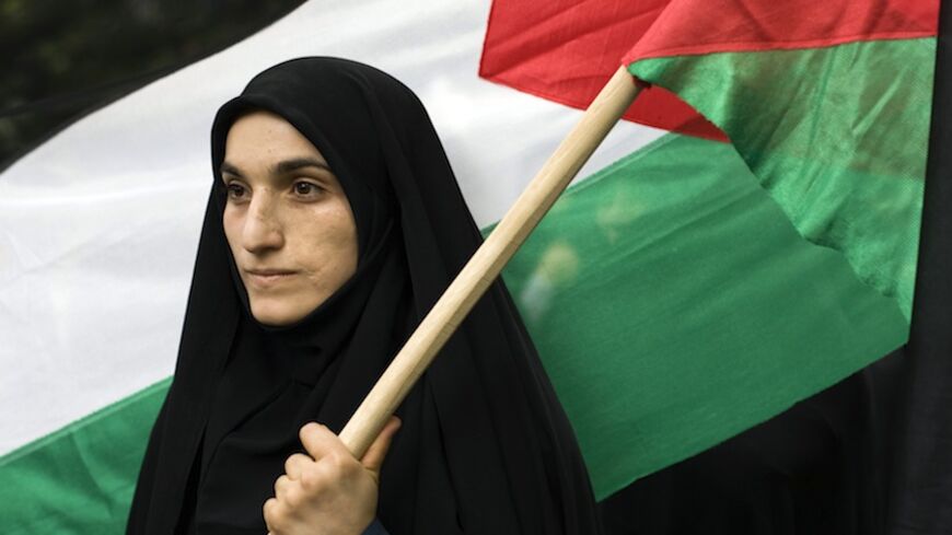 EDITORS' NOTE: Reuters and other foreign media are subject to Iranian restrictions on leaving the office to report, film or take pictures in Tehran.

A woman holds a Palestinian flag outside the United Nations headquarters building in Tehran during a protest against the Israeli attack on ships carrying aid to Gaza May 31, 2010.   REUTERS/Caren Firouz  (IRAN) - RTR2ELGC