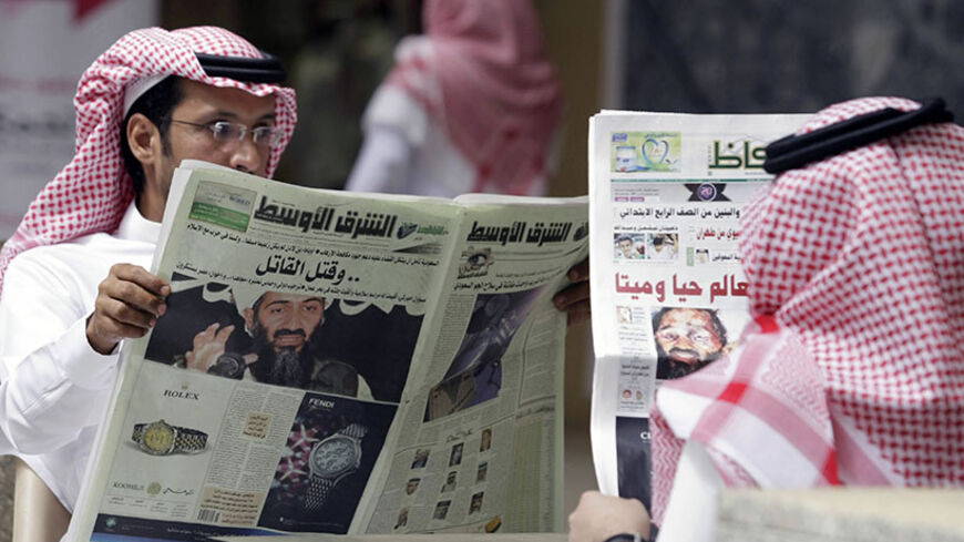 People read the newspapers with cover stories of Osama bin Laden, in Riyadh, May 3, 2011. Bin Laden was killed in a U.S. special forces assault on a Pakistani compound, then quickly buried at sea, in a dramatic end to the long manhunt for the al Qaeda leader who had been the guiding star of global terrorism. REUTERS/Mohammed Mashhor (SAUDI ARABIA - Tags: SOCIETY MEDIA) - RTR2LXUQ