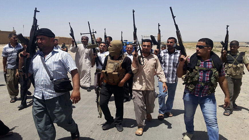 Tribal fighters and members of Iraqi security forces take part in an intensive security deployment on the outskirts of Diyala province June 14, 2014. The insurgent offensive that has threatened to dismember Iraq spread to the northwest of the country on Sunday, when Sunni militants launched a dawn raid on a town close to the Syrian border, clashing with police and government forces. Picture taken June 14, 2014. REUTERS/Stringer (IRAQ - Tags - Tags: CIVIL UNREST POLITICS TPX IMAGES OF THE DAY) - RTR3TVVI