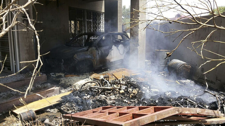Smoke rises from debris and a burnt car after a house was destroyed in a bomb attack in Fallujah, west of Baghdad July 19, 2014. The shelling of the city of Fallujah on Saturday killed 13 people and injured 17 others, according to police. Picture taken July 19, 2014.  REUTERS/Stringer (IRAQ - Tags: CIVIL UNREST POLITICS CONFLICT) - RTR3ZEH4
