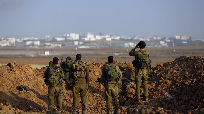 Israeli soldiers look towards Gaza from Israel August 3, 2014. The fighting on Sunday pushed the Gaza death toll given by Palestinian officials to 1,726, most of them civilians. Israel has confirmed that 64 soldiers have died in combat, while Palestinian rockets have also killed three civilians in Israel. Israel began its air and naval offensive against Gaza on July 8 following a surge of cross-border rocket salvoes by Hamas and other guerrillas, later escalating the operation into ground incursions. RE