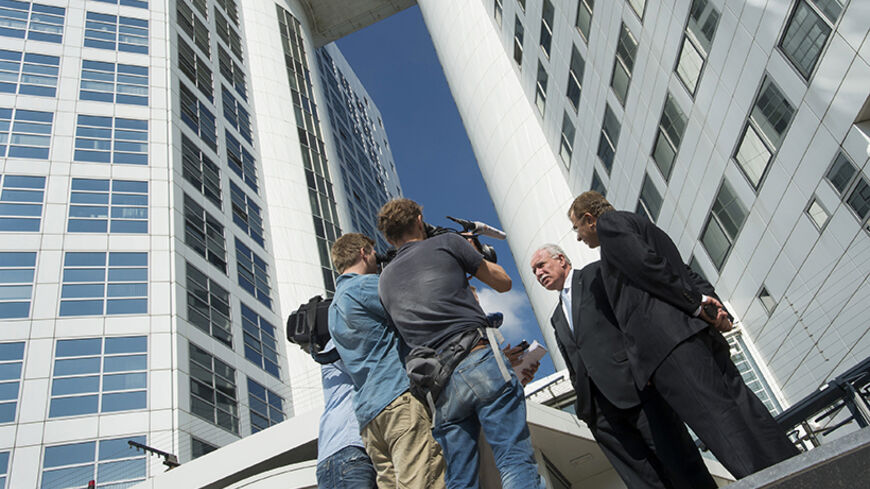 Palestinian Foreign Minister Riad al-Malki (2nd R) speaks to the media as he leaves the International Criminal Court after his visit, at the Hague August 5, 2014. Al-Malki said on Tuesday after meeting prosecutors at the International Criminal Court that there was "clear evidence" that Israel committed war crimes in Gaza. The visit took place shortly after Israel and the Islamist Hamas movement entered a 72-hour truce mediated by Egypt in an effort to pave the way for an extended ceasefire. Israel and the P