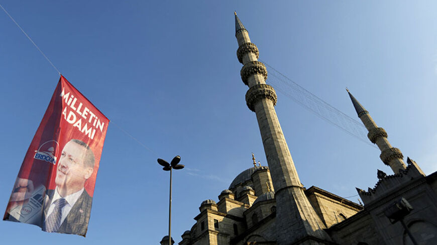 An election campaign banner of Turkey's Prime Minister and presidential candidate Tayyip Erdogan is seen near a mosque in Istanbul August 9, 2014. Erdogan is set to secure his place in history as Turkey's first popularly-elected president on Sunday, but his tightening grip on power has polarised the nation, worried Western allies and raised fears of creeping authoritarianism. REUTERS/Murad Sezer (TURKEY  - Tags: POLITICS ELECTIONS) - RTR41T1P