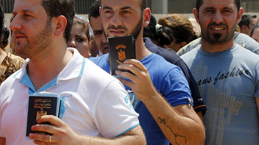 Iraqi Christians displaced by the violence in their country wait in line to receive aid from a Chaldean Catholic Church truck in Beirut August 13, 2014. Well financed and armed, Islamic State insurgents have captured large swathes of territory in a summer offensive, as the Iraqi army - and now Kurdish Peshmerga forces in the self-governing north - have crumbled in the face of its onslaught, massacring Shi'ites and minority Christians and Yazidis as they advance.  REUTERS/Mohamed Azakir (LEBANON - Tags: POLI