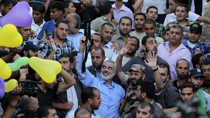 Hamas Gaza leader Ismail Haniyeh holds a gun as he appears for the first time since the start of a seven-week conflict during a rally by Palestinians celebrating what they said was a victory over Israel, in Gaza City August 27, 2014. An open-ended ceasefire in the Gaza war held on Wednesday as Prime Minister Benjamin Netanyahu faced strong criticism in Israel over a costly conflict with Palestinian militants in which no clear victor emerged. REUTERS/Suhaib Salem (GAZA - Tags: POLITICS CIVIL UNREST CONFLICT