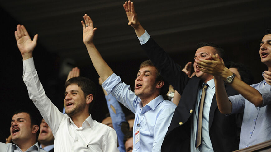Supporters of Turkey's Prime Minister Tayyip Erdogan (not pictured) cheer as he addresses the members of parliament from his ruling AK Party (AKP) during a meeting at the Turkish parliament in Ankara June 18, 2013. REUTERS/Stringer (TURKEY - Tags: POLITICS) - RTX10RT1