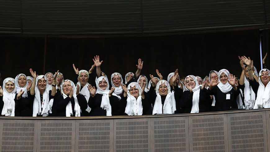 Supporters of Turkey's Prime Minister Tayyip Erdogan (not pictured) cheer as he addresses the members of parliament from his ruling AK Party (AKP) during a meeting at Turkish parliament in Ankara June 25, 2013. Turkish anti-terrorism police detained 20 people in raids in the capital Ankara on Tuesday in connection with weeks of anti-government protests across the country, media reports said. REUTERS/Umit Bektas (TURKEY - Tags: POLITICS) - RTX11029