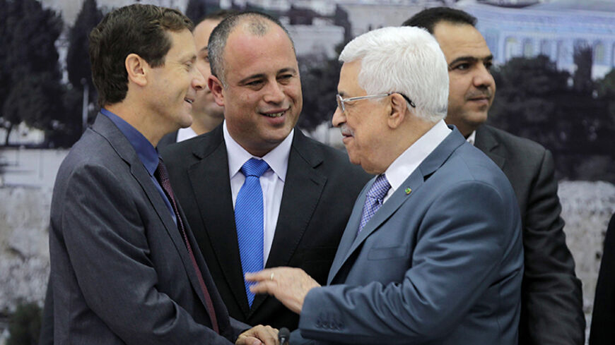 Israeli parliament members Isaac Herzog (L) and Hilik Bar (C) shake hands with Palestinian President Mahmoud Abbas as they attend a meeting in the West Bank city of Ramallah October 7, 2013. Abbas held a rare meeting with the group of Israeli parliamentarians on Monday, warning that this could be the last chance to reach a deal to end decades of Israeli-Palestinian conflict and create two independent states living side-by-side. REUTERS/Abbas Momani/Pool (WEST BANK - Tags: POLITICS) - RTX142QP